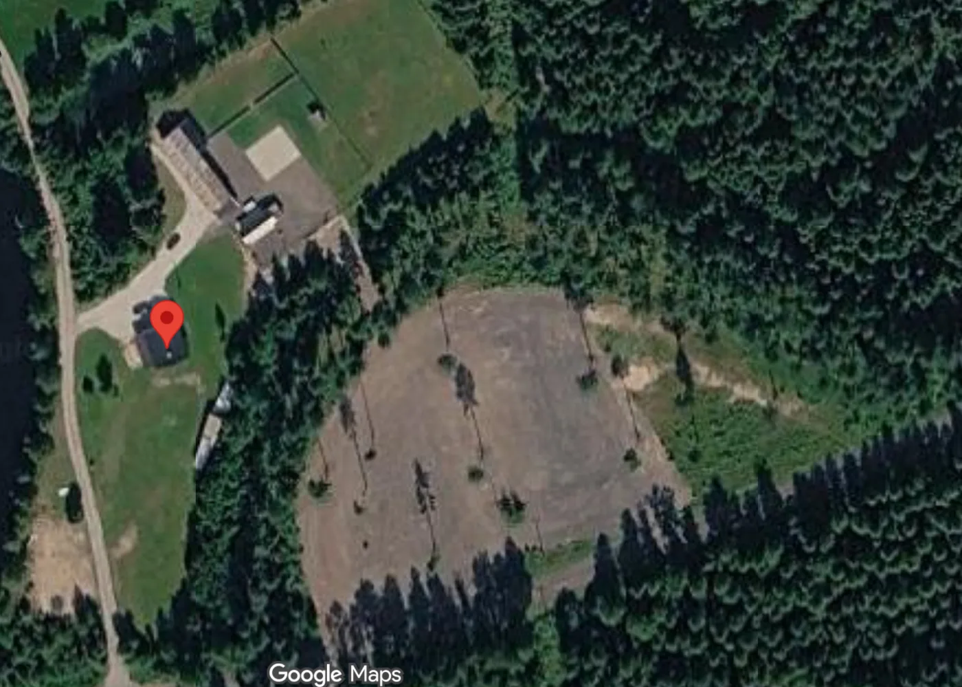 Flygbild över området vid Bastvålsvägen 9 i Östmark. Den stora grå ytan i mitten är parkeringen för festivalen.